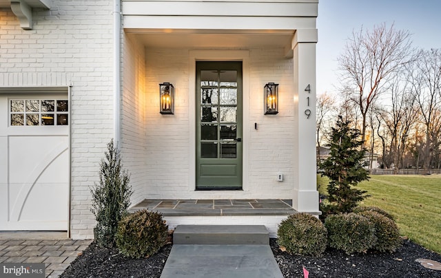 exterior entry at dusk featuring a garage