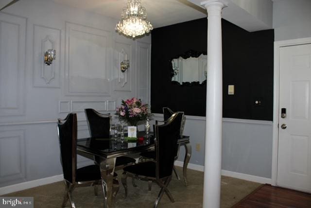 dining area featuring decorative columns and a notable chandelier