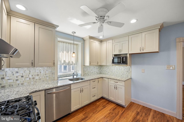 kitchen with stainless steel dishwasher, ceiling fan, sink, cream cabinetry, and hardwood / wood-style floors