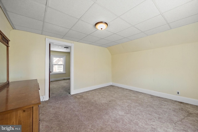 carpeted empty room with a drop ceiling and lofted ceiling