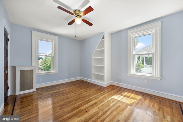 unfurnished living room featuring ceiling fan and wood-type flooring