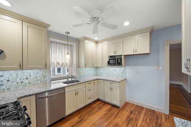 kitchen featuring ceiling fan, sink, stainless steel dishwasher, cream cabinetry, and light wood-type flooring