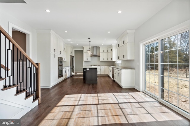 kitchen with pendant lighting, a kitchen island, white cabinets, and stainless steel appliances