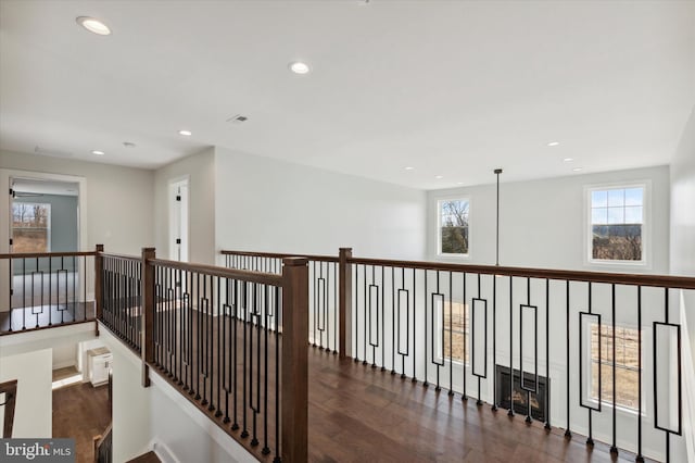 corridor with plenty of natural light and dark hardwood / wood-style floors