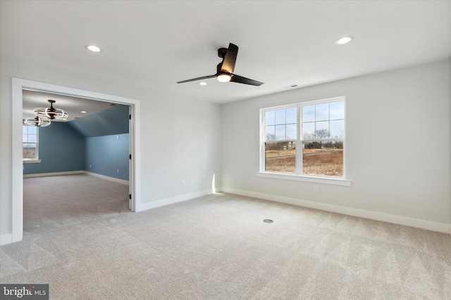 carpeted empty room featuring a wealth of natural light, vaulted ceiling, and ceiling fan