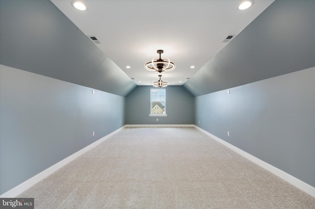 additional living space featuring light colored carpet and vaulted ceiling