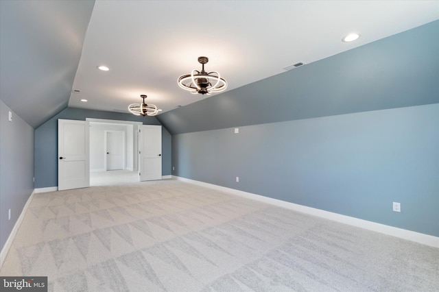 bonus room with light colored carpet and vaulted ceiling