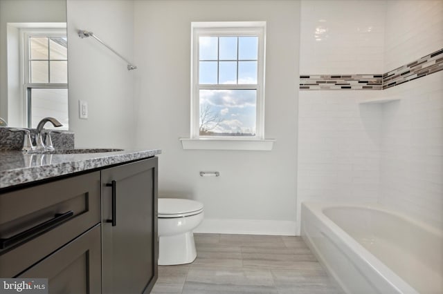 full bathroom with vanity, toilet, a wealth of natural light, and tiled shower / bath combo