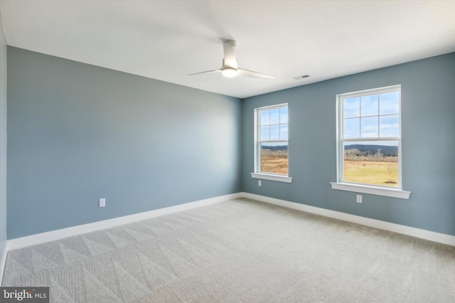 carpeted spare room featuring ceiling fan