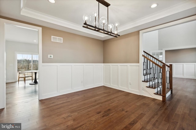 unfurnished dining area with crown molding, dark hardwood / wood-style flooring, and a notable chandelier