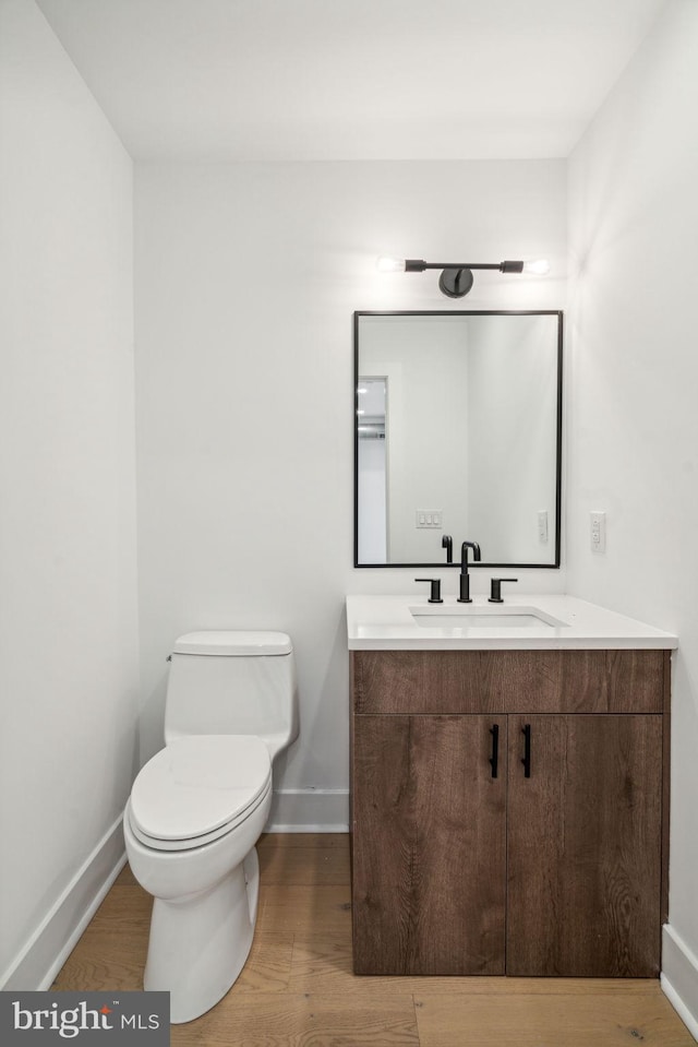 bathroom featuring hardwood / wood-style floors, vanity, and toilet