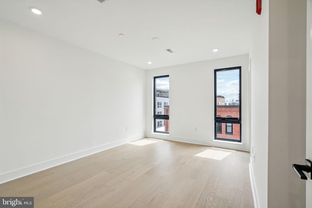 unfurnished room with light wood-type flooring