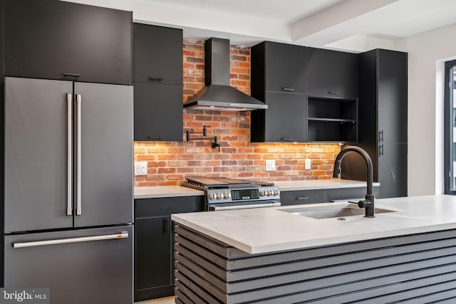 kitchen with backsplash, sink, wall chimney exhaust hood, an island with sink, and stainless steel appliances