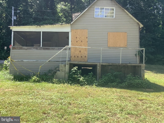 rear view of property featuring a yard