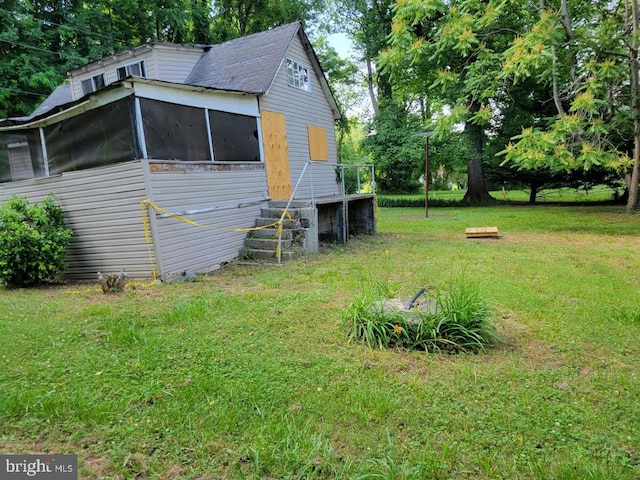 view of side of home with a yard and a sunroom