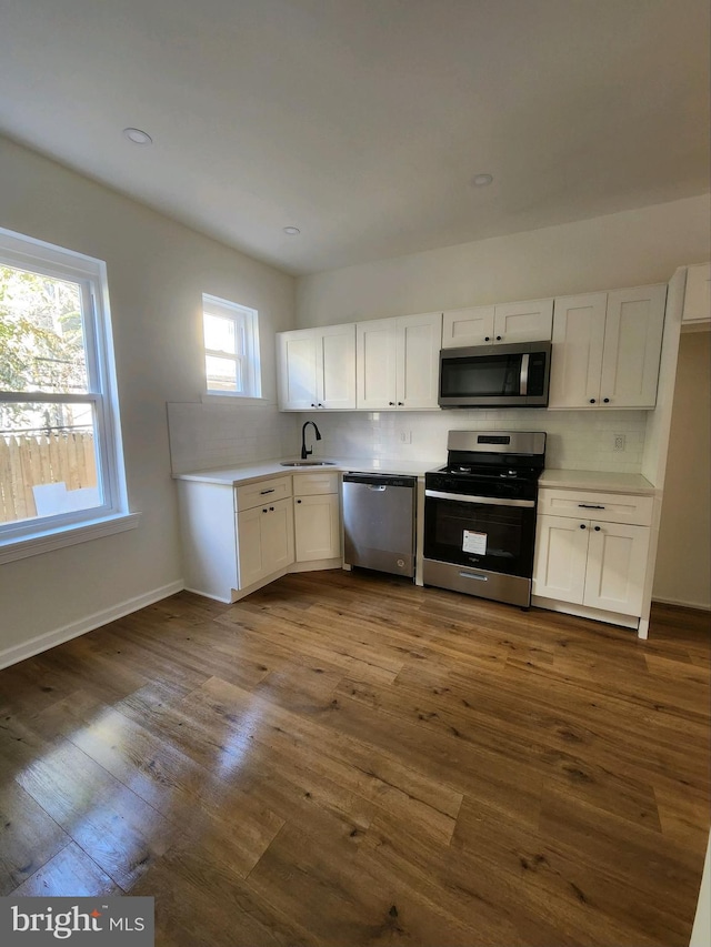 kitchen featuring white cabinets, sink, appliances with stainless steel finishes, and dark wood-type flooring