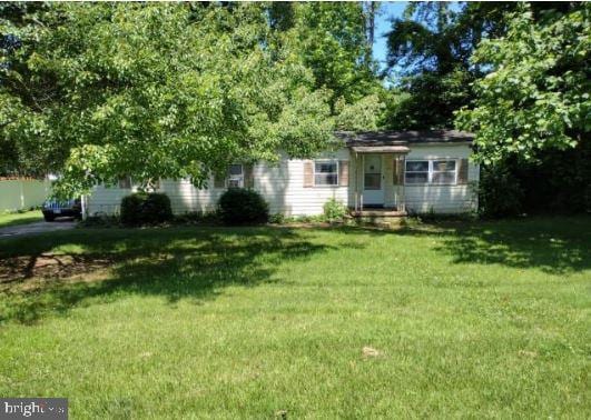 obstructed view of property with a front lawn