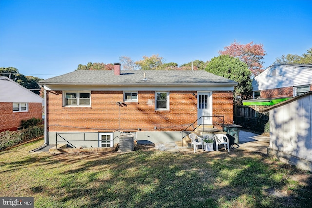 back of house featuring central AC unit and a lawn