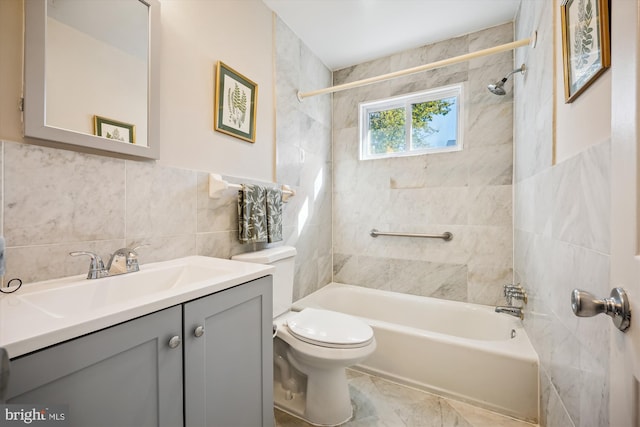 full bathroom featuring tile walls, vanity, tiled shower / bath combo, and toilet