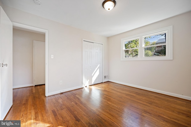 unfurnished bedroom featuring dark wood-type flooring and a closet