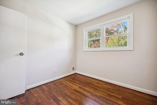 spare room with dark wood-type flooring