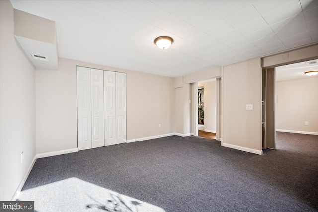 unfurnished bedroom with a closet and dark colored carpet