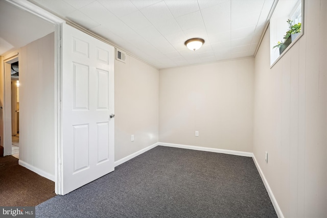 unfurnished room with dark colored carpet