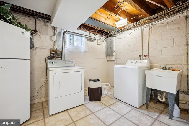 laundry room with washer and clothes dryer, electric panel, and sink