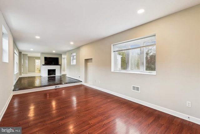 unfurnished living room featuring baseboards, recessed lighting, a fireplace, visible vents, and wood-type flooring