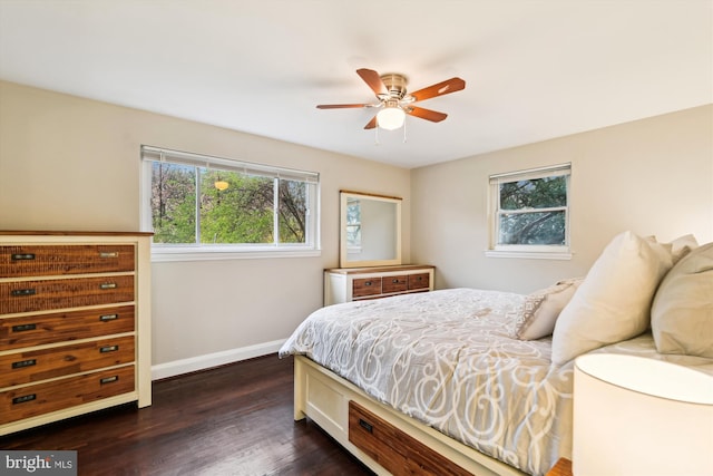 bedroom featuring dark wood-type flooring, multiple windows, baseboards, and ceiling fan