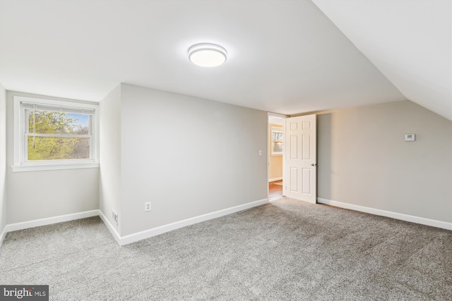 additional living space featuring baseboards, lofted ceiling, and carpet