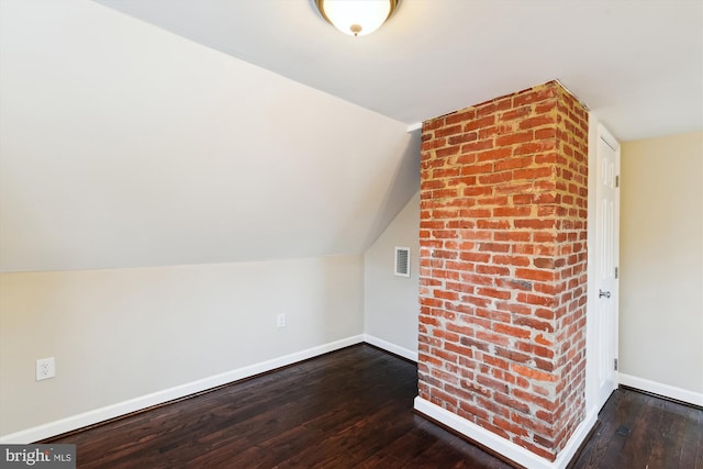 bonus room with lofted ceiling, visible vents, baseboards, and dark wood finished floors