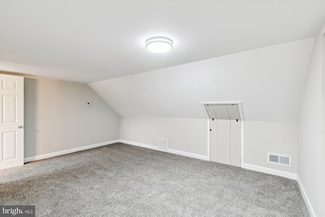 bonus room featuring visible vents, baseboards, vaulted ceiling, and carpet floors