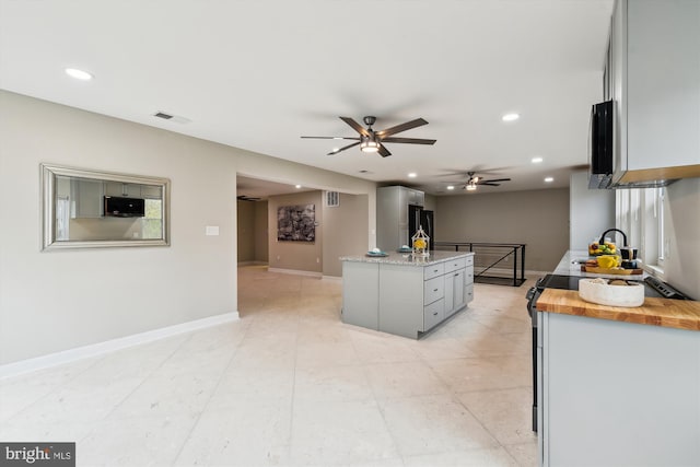 kitchen with visible vents, a ceiling fan, freestanding refrigerator, stainless steel microwave, and recessed lighting
