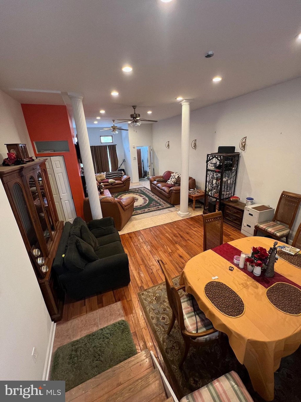 living room featuring hardwood / wood-style flooring, ceiling fan, and ornate columns