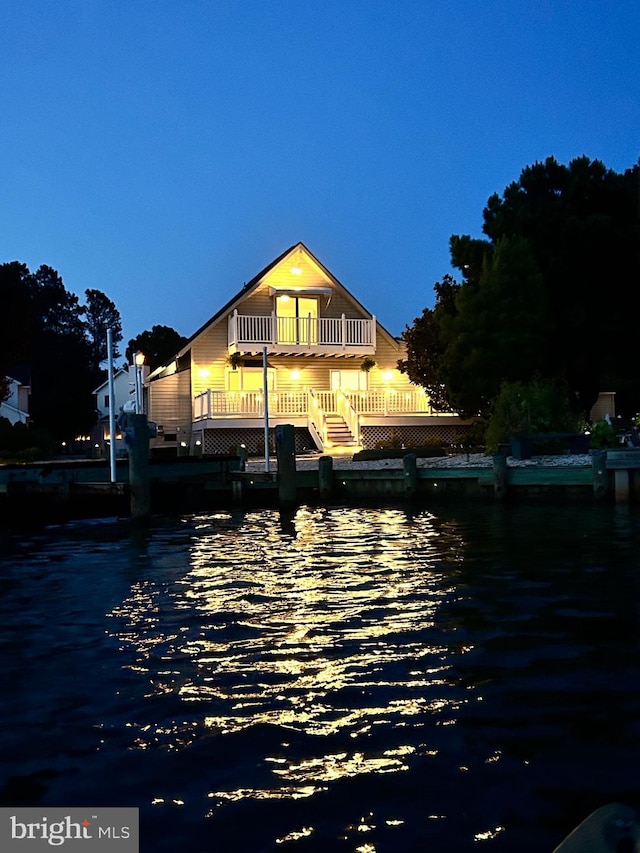 rear view of property with a balcony and a water view