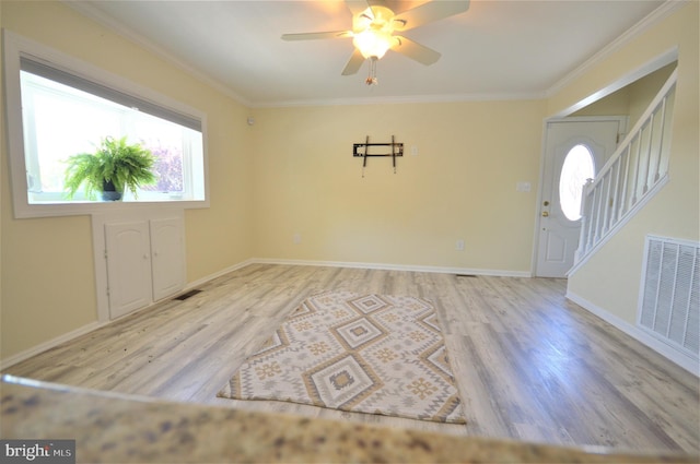 entrance foyer featuring ornamental molding, ceiling fan, and light hardwood / wood-style floors