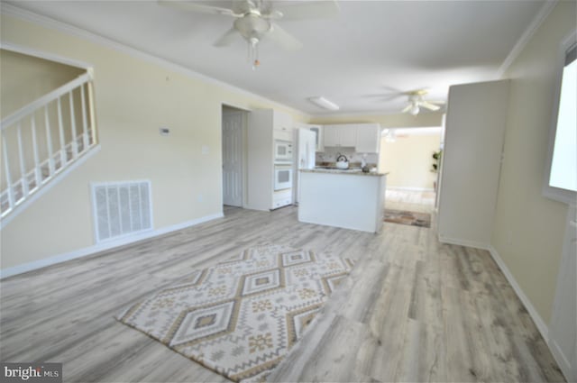 unfurnished living room with ceiling fan, ornamental molding, and light hardwood / wood-style flooring