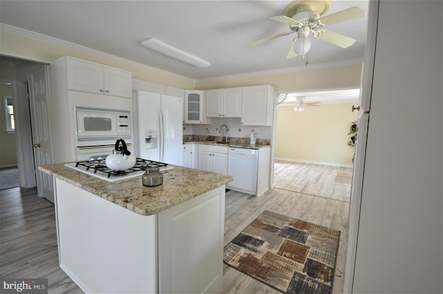 kitchen with white cabinetry, white appliances, crown molding, and a kitchen island