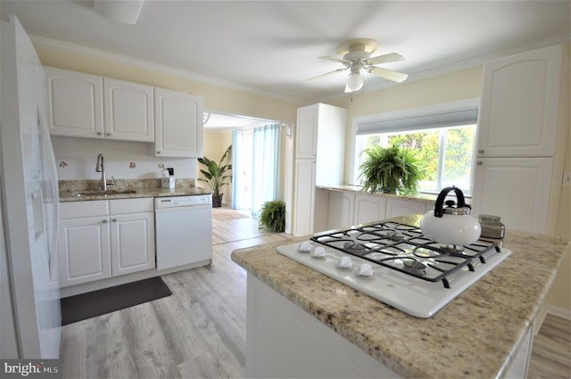 kitchen with crown molding, white appliances, sink, and white cabinets