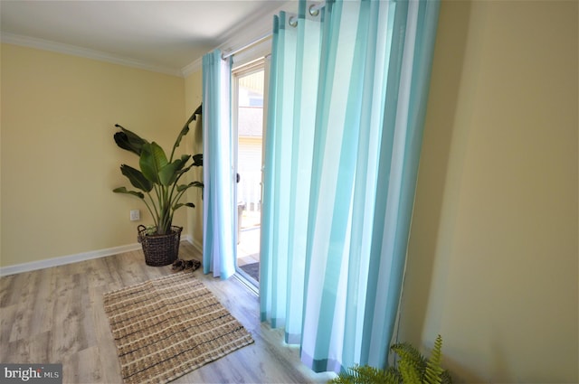 hallway featuring crown molding and light hardwood / wood-style flooring