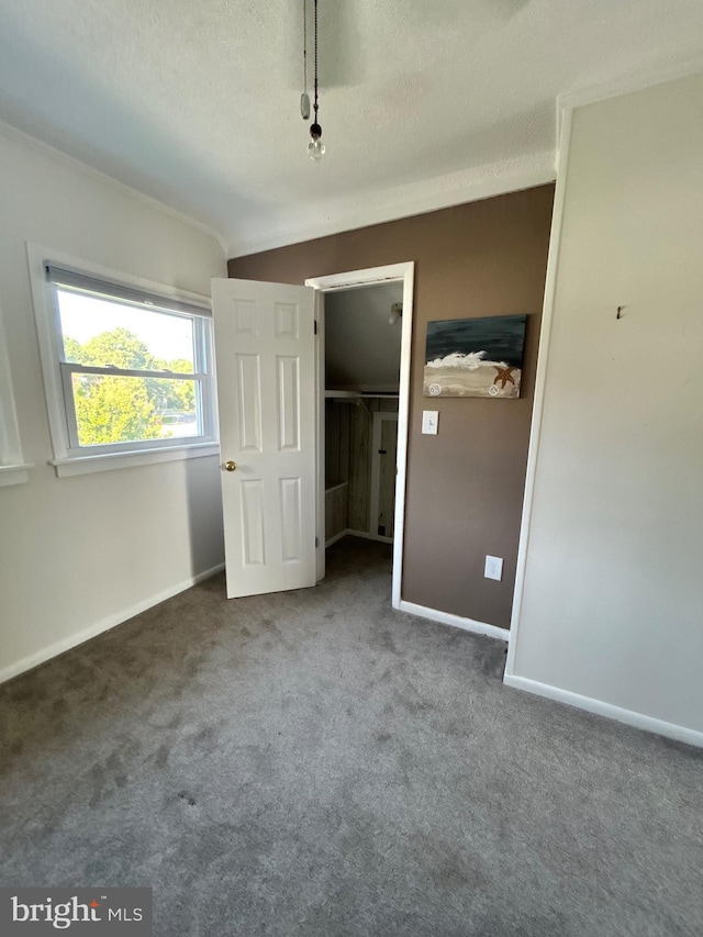 unfurnished bedroom with a textured ceiling and carpet