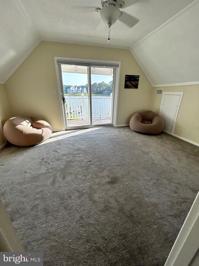 bonus room featuring ceiling fan, a water view, carpet floors, a textured ceiling, and vaulted ceiling