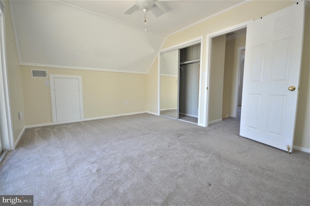 unfurnished bedroom with ceiling fan, ornamental molding, vaulted ceiling, light colored carpet, and a closet