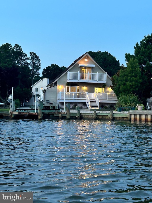 back of property featuring a water view and a balcony