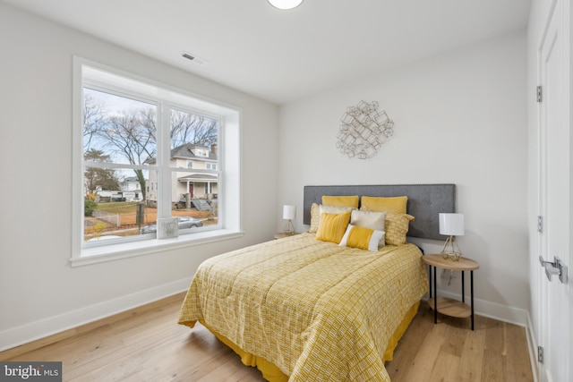 bedroom featuring multiple windows and hardwood / wood-style floors