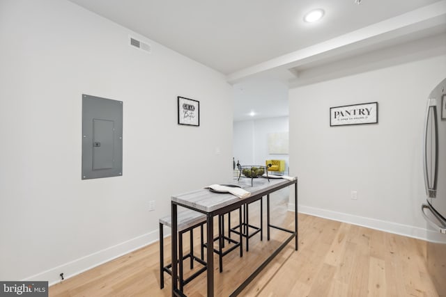 dining room with electric panel and light hardwood / wood-style floors