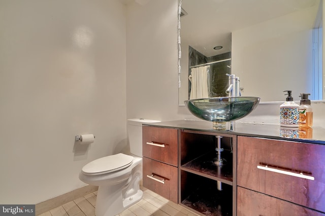 bathroom with toilet, vanity, a shower with curtain, and tile patterned floors