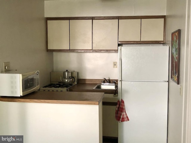 kitchen featuring white appliances and sink