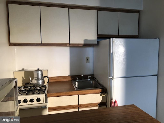 kitchen featuring white appliances and sink